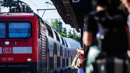 Les passagers attendent à la gare de Stralsund, en Allemagne, un train régional, le 02 juillet 2022. (STEFAN SAUER / DPA)