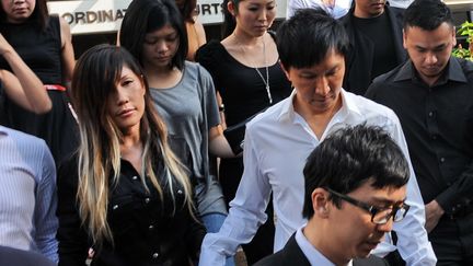 Le pasteur Kong Hee (chemise blanche) et sa femme,&nbsp;Ho Yeow Sun, quittent le tribunal &agrave;&nbsp;Singapour, le 27 juin 2012. (ROSLAN RAHMAN / AFP)