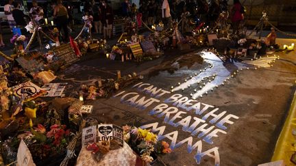 Depuis un an, l'intersection où George Floyd s'est transformée en mémorial. Ses derniers mots sont inscrits sur le sol, à l'endroit où il est mort asphyxié sous le genou d'un policier : "Je ne peux pas respirer". (KEREM YUCEL / AFP)