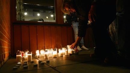 Une femme allume une bougie &agrave; la m&eacute;moire des victimes de l'attaque, le 22 octobre &agrave;&nbsp;Trollh&auml;ttan (Su&egrave;de). (JONATHAN NACKSTRAND / AFP)