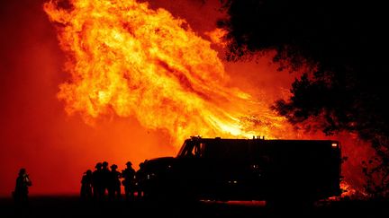 Les pompiers du comté de Butte regardent les flammes tourbillonner au-dessus de leur camion lors de l'incendie de Bear à Oroville, en Californie, le 9 septembre 2020. (JOSH EDELSON / AFP)