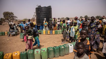 Des réfugiés font la queue pour avoir de l'eau dans un camp à Barsalogho, au Burkina Faso, le 27 janvier 2020. (OLYMPIA DE MAISMONT / AFP)