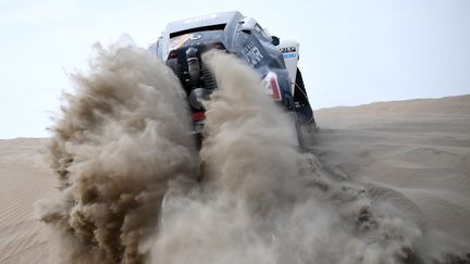 La voiture pilotée par Oscar Fuertes avec Diego Vallejo comme co-pilote franchit une dune vers la ville de Pisco (Perou), dans l'étape du 7 janvier 2018.&nbsp;&nbsp; (FRANCK FIFE / AFP)