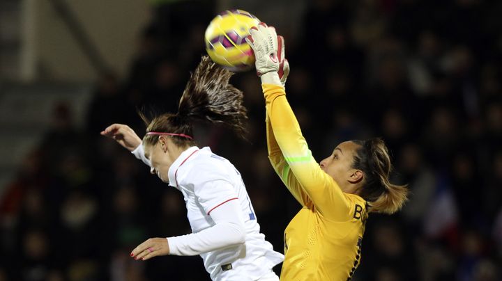 La gardienne de l'&eacute;quipe de France, Sarah Bouhaddi (en jaune), s'empare du ballon face &agrave; l'Am&eacute;ricaine Tobin Heath, lors d'un match amical, le 8 f&eacute;vrier 2015 au stade du Moustoir de Lorient. (EDDY LEMAISTRE / 2PIX-EL)