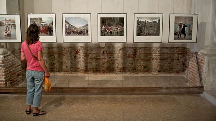 Une femme observe des photos exposées au festival Visa pour l'image, le 4 septembre 2015 à Perpignan (NICOLAS MESSYASZ / SIPA)