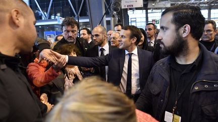 Alexandre Benalla (à droite), le 1er mars 2017 aux côtés d'Emmanuel Macron au salon de l'Agriculture. (LIONEL BONAVENTURE / AFP)