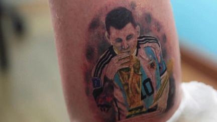 Les tatouages de Lionel Messi, grand artisan du sacre de l'Argentine lors du Mondial 2022 au Qatar, se multiplient sur les bras, les cuisses et les mollets de ses fans. (FRANCEINFO)