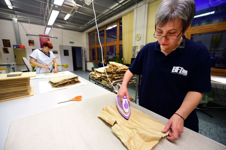 Deux employées des archives municipales de Budapest (Hongrie) photographiées&nbsp;le 12 novembre 2015,&nbsp;repassent les documents recensant les Juifs de la ville en 1944. (ATTILA KISBENEDEK / AFP)