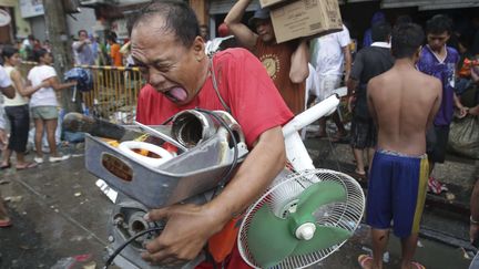 Un habitant de Tacloban (Philippines) pillant un magasin du passage du typhon Haiyan, le 10 novembre 2013. (AARON FAVILA / AP / SIPA)