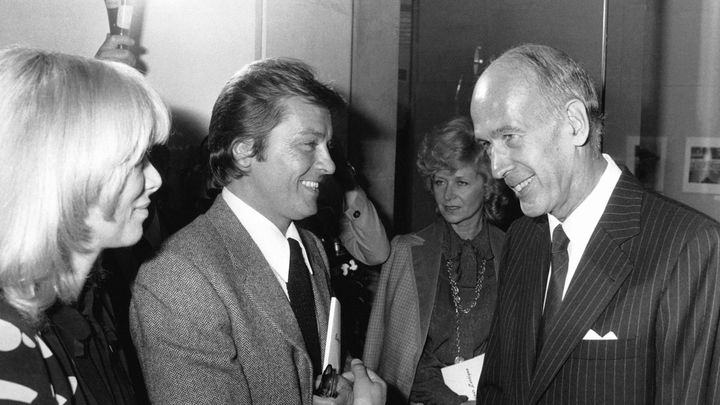 Mireille Darc, Alain Delon et le président de la République Valéry Giscard d'Estaing à l'exposition du photographe Jacques Henri Lartigue, au Grand-Palais, en 1980 à Paris. (MICHEL GINFRAY / GAMMA-RAPHO / GETTY IMAGES)