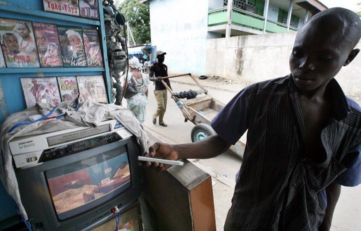 Un homme lançant un film Nollywood dans les rues d'Abidjan (16 juin 2007). (KAMBOU SIA / AFP)