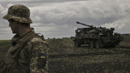 Un soldat se tient devant un canon Caesar, dans la région du Donbass (Ukraine), le 15 juin 2022. (ARIS MESSINIS / AFP)