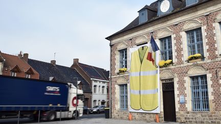 Une affiche avec un gilet jaune sur la façade de la mairie de&nbsp;Morbecque&nbsp;(Nord), le 15 novembre 2018. (FRANCOIS LO PRESTI / AFP)