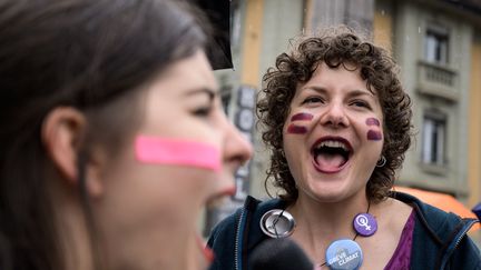 Deux femmes dans les rues de Lausanne, en Suisse, le 14 juin 2019, manifestent pour réclamer&nbsp;davantage d'égalité salariale. (FABRICE COFFRINI / AFP)