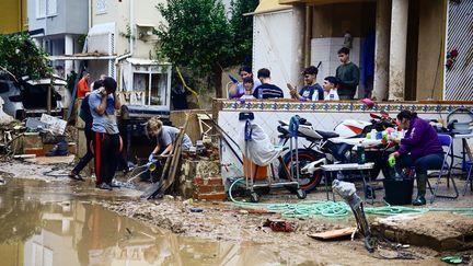 Des habitants continuent de déblayer une rue inondée à Alfafar, dans la région de Valence (Espagne), le 4 novembre 2024. (JOSE JORDAN / AFP)