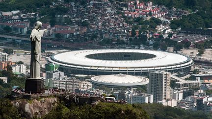 Le Christ du Corcovado, symbole de Rio et du Br&eacute;sil, et en arri&egrave;re-plan le mythique stade de Maracana, o&ugrave; se d&eacute;roulera la finale de la Coupe du monde, le 13 juillet prochain. (YASUYOSHI CHIBA / AFP )