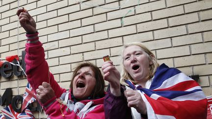 Des fans c&eacute;l&egrave;brent l'annonce de la naissance de la fille de Kate Middleton et du Prince William, devant la maternit&eacute;&nbsp;St Mary's de Londres, le 2 mai 2015. (JUSTIN TALLIS / AFP)