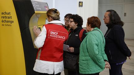 Une employ&eacute;e de la SNCF aide des voyageurs lors d'une gr&egrave;ve, &agrave; la gare d'Austerlitz, &agrave; Paris, le 19 juin 2014. (STEPHANE DE SAKUTIN / AFP)