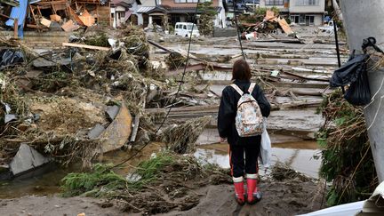 Une femme regarde les dégâts causés par le typhon à Nagano, le 15 octobre 2019. (KAZUHIRO NOGI / AFP)