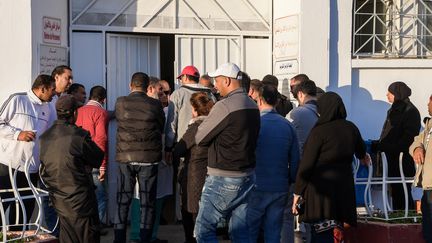 Des membres des familles de certains des onze nouveau-nés morts en deux jours dans la maternité de la Rabta, à Tunis (Tunisie), devant l'une des entrées de l'établissement, le 9 mars 2019. (FETHI BELAID / AFP)