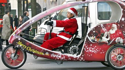 Depuis plus de 80 ans, Coca Cola met le Père Noël à la sauce soda dans ses campagnes publicitaires, comme ici à Tokyo, en décembre 2006. (AFP)