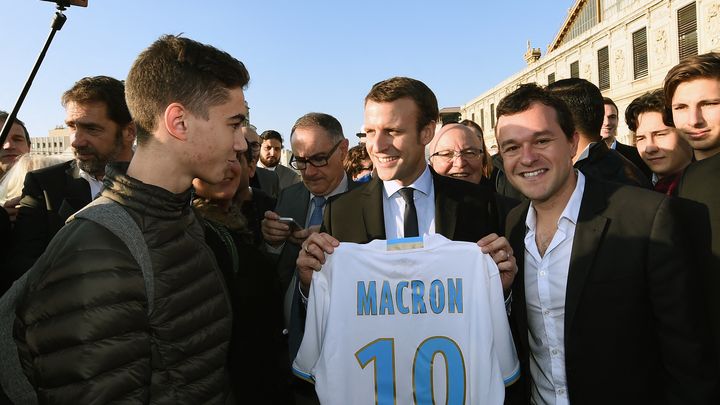 Emmanuel Macron, alors ministre de l'Economie, pose le 17 novembre 2016 à Marseille avec un maillot de l'OM à son nom. (BORIS HORVAT / AFP)