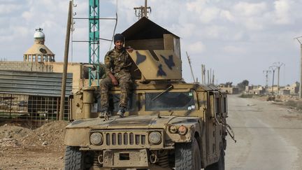 Un soldat des Forces démocratiques syriennes sur un blindé dans une rue de Baghouz (Syrie), le 18 février 2019. (ABOUD HAMAM / DPA)