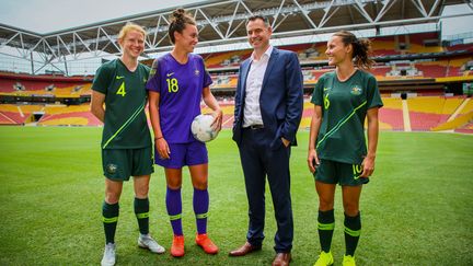 Clare Polkinghorne, Mackenzie Arnold and Hayley Raso posent avec leur coach Ante Milicic, dans le stade de Brisbane (Australie), le 21 février 2019. (PATRICK HAMILTON / AFP )