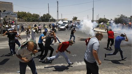 &nbsp; (Des Palestiniens fuient les tirs de gaz lacrymogènes lancés par les soldats israéliens vendredi 4 juillet à Jérusalem-Est.  © REUTERS / Ammar Awad)