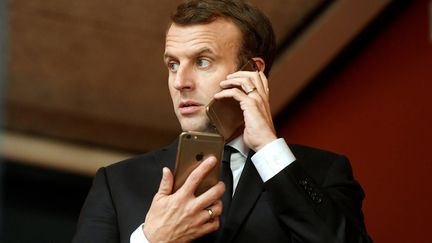 Le président français Emmanuel Macron utilisant deux iPhone, lors d'un sommet européen à Gothenburg (Suède) le 17 novembre 2017 (SZILARD KOSZTICSAK / MTI)