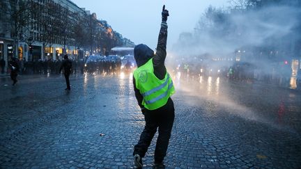 Un "gilet jaune" devant les forces de l'ordre lors de "l'acte&nbsp;5" du mouvement sur les Champs-Elysées, à Paris, le 15&nbsp;décembre&nbsp;2018.&nbsp; (ZAKARIA ABDELKAFI / AFP)