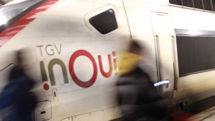 Des passagers marchent devant un TGV InOui de la SNCF en gare de Lille Flandres un soir de février 2020.&nbsp; (AURÉLIEN ACCART / RADIO FRANCE)