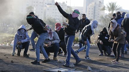 Des Palestiniens s'opposent aux forces de sécurité israéliennes, à Ramallah, le 8 décembre 2017. (ABBAS MOMANI / AFP)