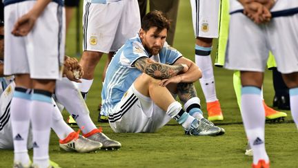 L'Argentin Lionel Messi prostré au milieu de ses coéquipiers à l'issue de la finale de la Copa America 2016 (NICHOLAS KAMM / AFP)