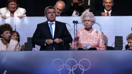 La Reine Elisabeth aux côtés de Thomas Bach, président du CIO, lors de la cérémonie d'ouverture des Jeux olympiques de Londres, le 27 juillet 2012. (MATT DUNHAM / AFP)