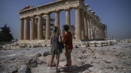 Des touristes devant l'Acropole à Athènes (Grèce).&nbsp; (ARIS MESSINIS / AFP)