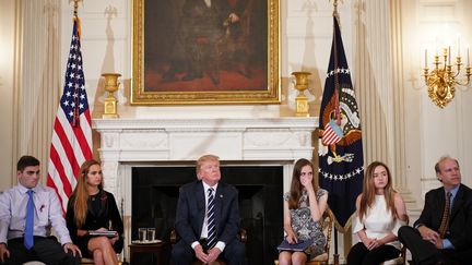 Donald Trump entouré d'étudiants et de professeurs lors d'une réunion sur les violences par armes à feu, à la Maison Blanche, à Washington, le 21 février 2018. (MANDEL NGAN / AFP)