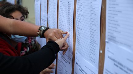 Des lycéens regardent les résultats du bac, à Saint-Denis (La Réunion), le 6 juillet 2021. (RICHARD BOUHET / AFP)