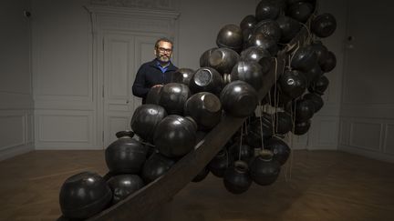 Subodh Gupta à la Monnaie de Paris, devant une de ses oeuvres ("Jal Mein Kumbh, Kumbh Mein Jal Hai"), le 5 avril 2018
 (Lionel Bonaventure / AFP)