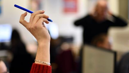 Une lycéenne lève la main dans une classe de terminale. Photo d'illustration. (ALEXANDRE MARCHI / MAXPPP)