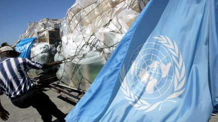 Un employé aide à décharger les fournitures médicales des Nations unies à l'aéroport international de Port-au-Prince (Haïti), le 3 mars 2004. (JAIME RAZURI / AFP)