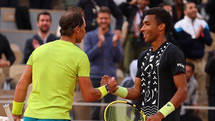 Rafael Nadal (gauche) et Félix Auger-Aliassime (droite) se saluent après la victoire du premier à Roland-Garros le 29 mai 2022. (THOMAS SAMSON / AFP)