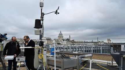 Des chercheurs du&nbsp;Laboratoire des sciences du climat et de l'environnement installent des capteurs de C02 sur la plateforme Qualair sur le toit de l'université de Jussieu, à Paris, le 20 octobre 2019. (DOMINIQUE FAGET / AFP)