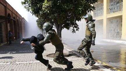 Un manifestant est attrap&eacute; par la police en marge d'une marche &agrave; l'occasion de l'anniversaire du coup d'&eacute;tat militaire de 1973 &agrave; Santiago (Chili), le 7 septembre 2014. (IVAN ALVARADO / REUTERS)