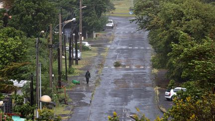 Un homme marche dans une rue d&eacute;sert&eacute;e de La Possession (La R&eacute;union), le 2 janvier 2014. (RICHARD BOUHET / AFP)