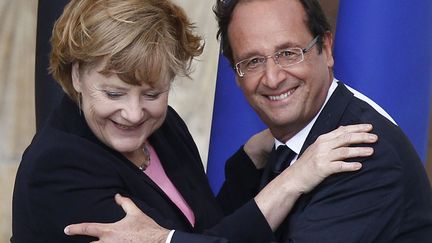 Le pr&eacute;sident fran&ccedil;ais Fran&ccedil;ois Hollande (D) et la chanceli&egrave;re allemande Angela Merkel lors de la c&eacute;r&eacute;monie de comm&eacute;moration des 50 ans de l'amiti&eacute; franco-allemande &agrave; Reims (Marne), le 8 juillet 2012. (JACKY NAEGELEN / AFP)