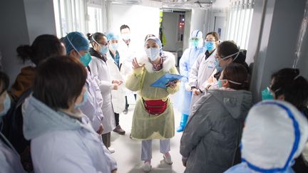 Une infirmière assigne les tâches de la journée avant l'accueil de malades du Covid-19, le 8 février 2020 à l'hôpital de Wuhan (Chine). (XIAO YIJIU / XINHUA / AFP)