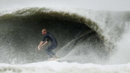 A Virginia Beach (Virginie), un peu plus au Sud sur la c&ocirc;te, un surfeur profite des grandes vagues provoqu&eacute;es par l'arriv&eacute;e de l'ouragan Sandy. (L TOOD SPENCER / AP /SIPA)