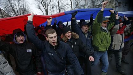 Des manifestants d&eacute;filent avec un drapeau russe en r&eacute;publique autonome de Crim&eacute;e, &agrave; Simferopol (Ukraine), le 27 f&eacute;vrier 2014. (DAVID MDZINARISHVILI / REUTERS)