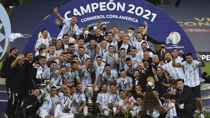 Les Argentins célèbrent sur le podium leur trophée après avoir remporté la finale de la Copa America face au Brésil au stade Maracana à Rio de Janeiro, le 10 juillet 2021.&nbsp; (CARL DE SOUZA / AFP)